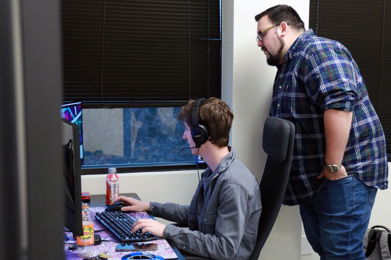 Image of two people in front of their workstation.